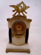 A miniature brass and alabaster continental desk clock on ball feet,