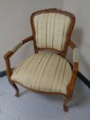 A French carved beech salon armchair upholstered in a classical striped fabric