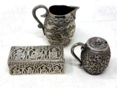 Three items of Indian white metal comprising trinket box, milk jug and sugar pot.