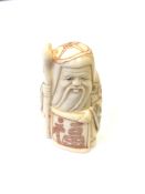 A Japanese carved bone netsuke - Village elder holding a scroll.