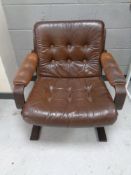 A 20th century Scandinavian stained beech framed armchair upholstered in a brown button leather