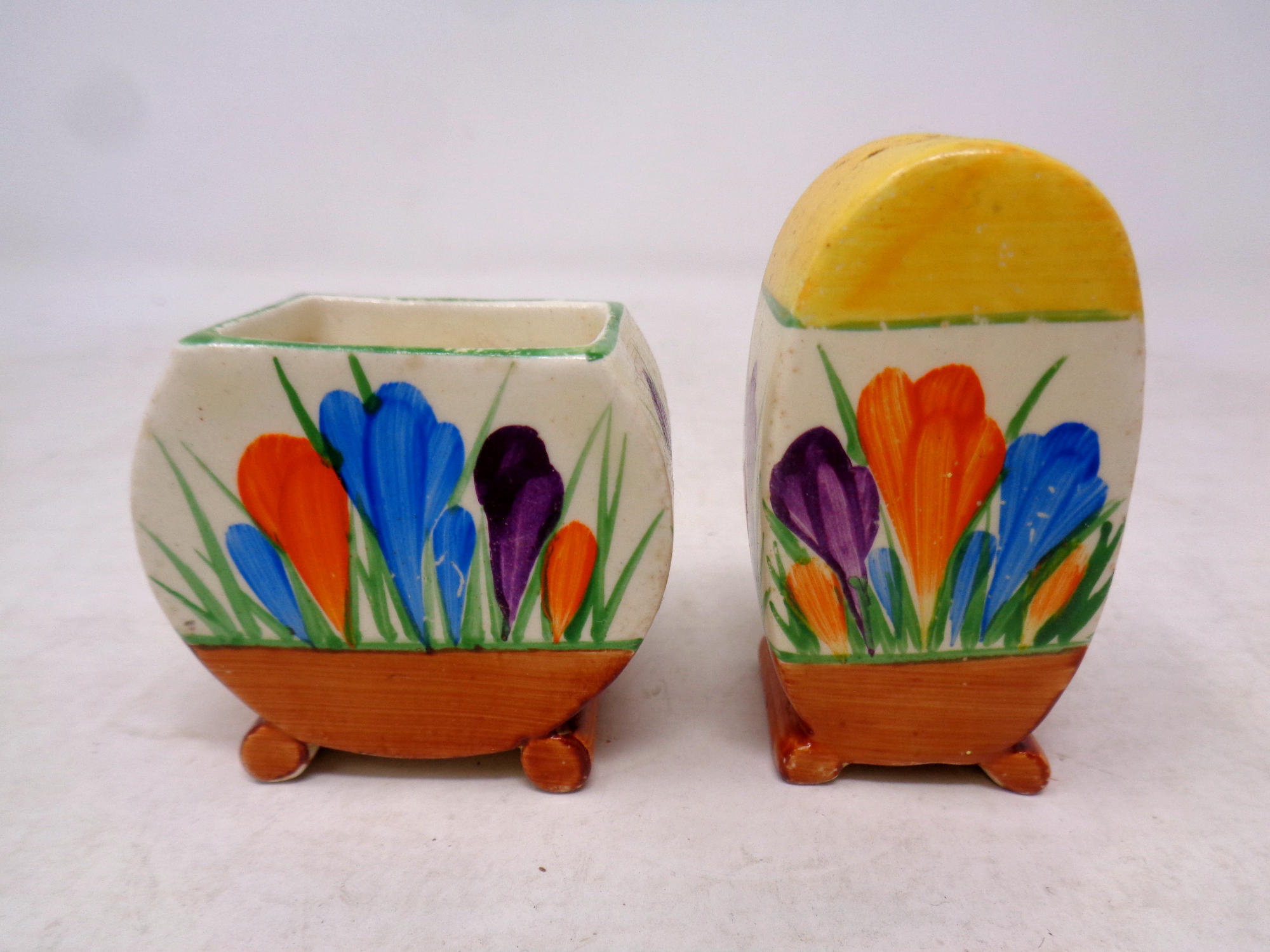 A Clarice Cliff Bizarre Newport Pottery hand painted pepper pot and mustard pot