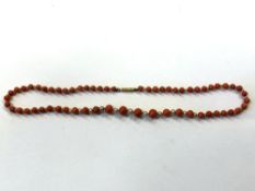 A single strand coral and pearl necklace with gold clasp