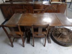 A 1930s oak pull out dining table with four chairs