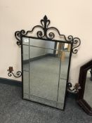 A metal framed ornate mirror with candle sconces,