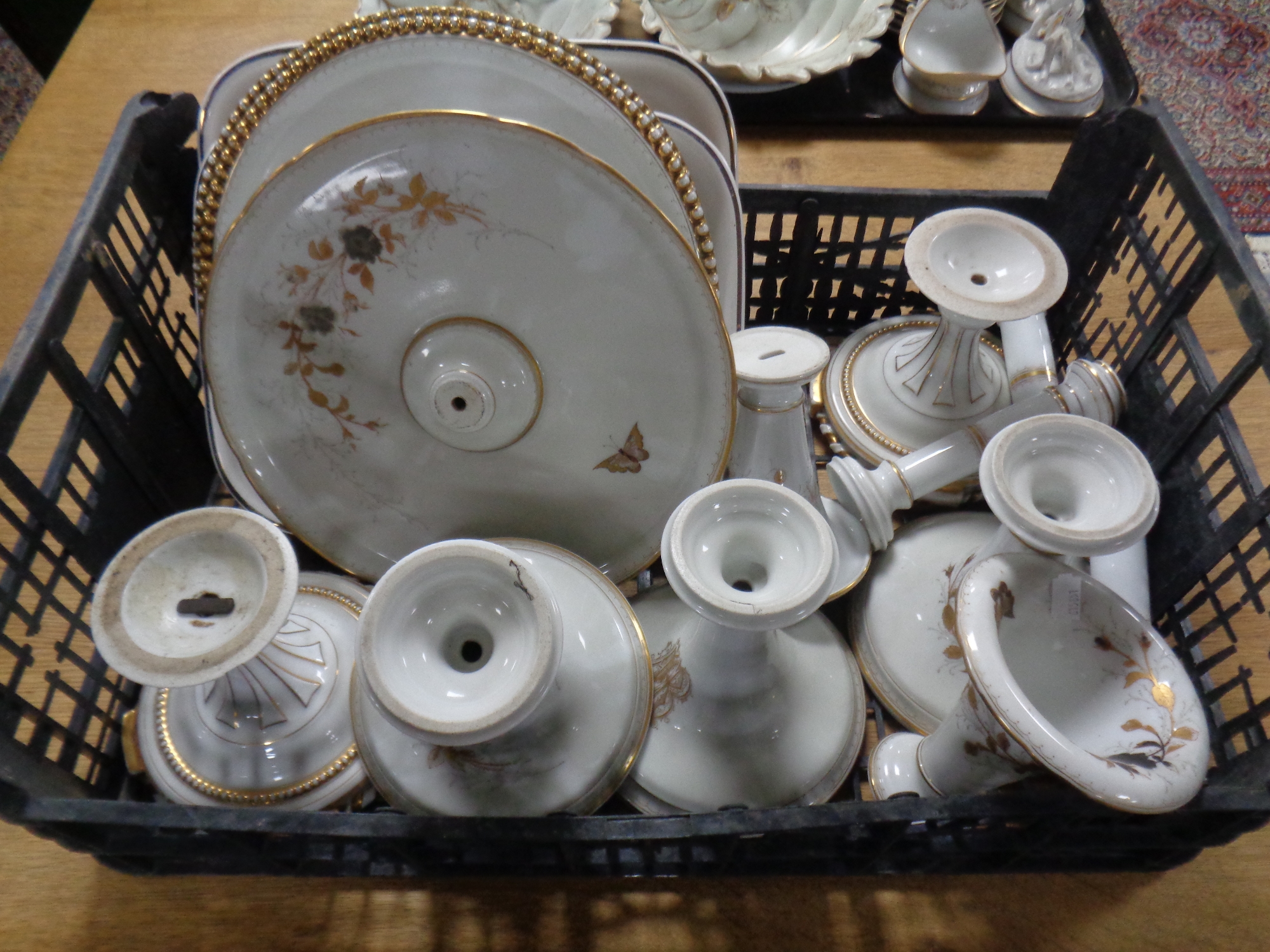A crate containing a quantity of 19th century white and gilt china comport parts, cake plates,