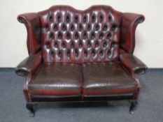 A Chesterfield oxblood two seater wingback settee