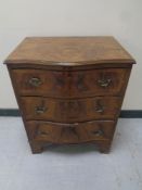 A Georgian style walnut serpentine fronted three drawer chest