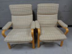 A pair of 20th century Scandinavian beech framed armchairs upholstered in a checkered beige fabric