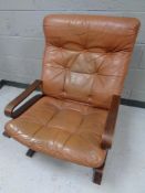 A 20th century Scandinavian beech framed relaxer chair upholstered in a brown button leather