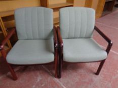 A pair of late 20th century stained beech armchairs upholstered in a green fabric