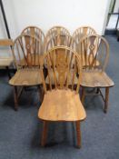 Seven oak wheel back dining chairs