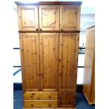 A contemporary pine triple door wardrobe fitted with two drawers with top boxes