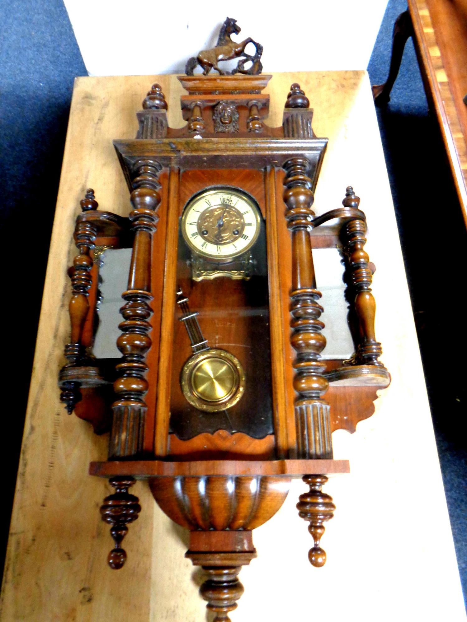 An antique Vienna wall clock with brass dial and pendulum