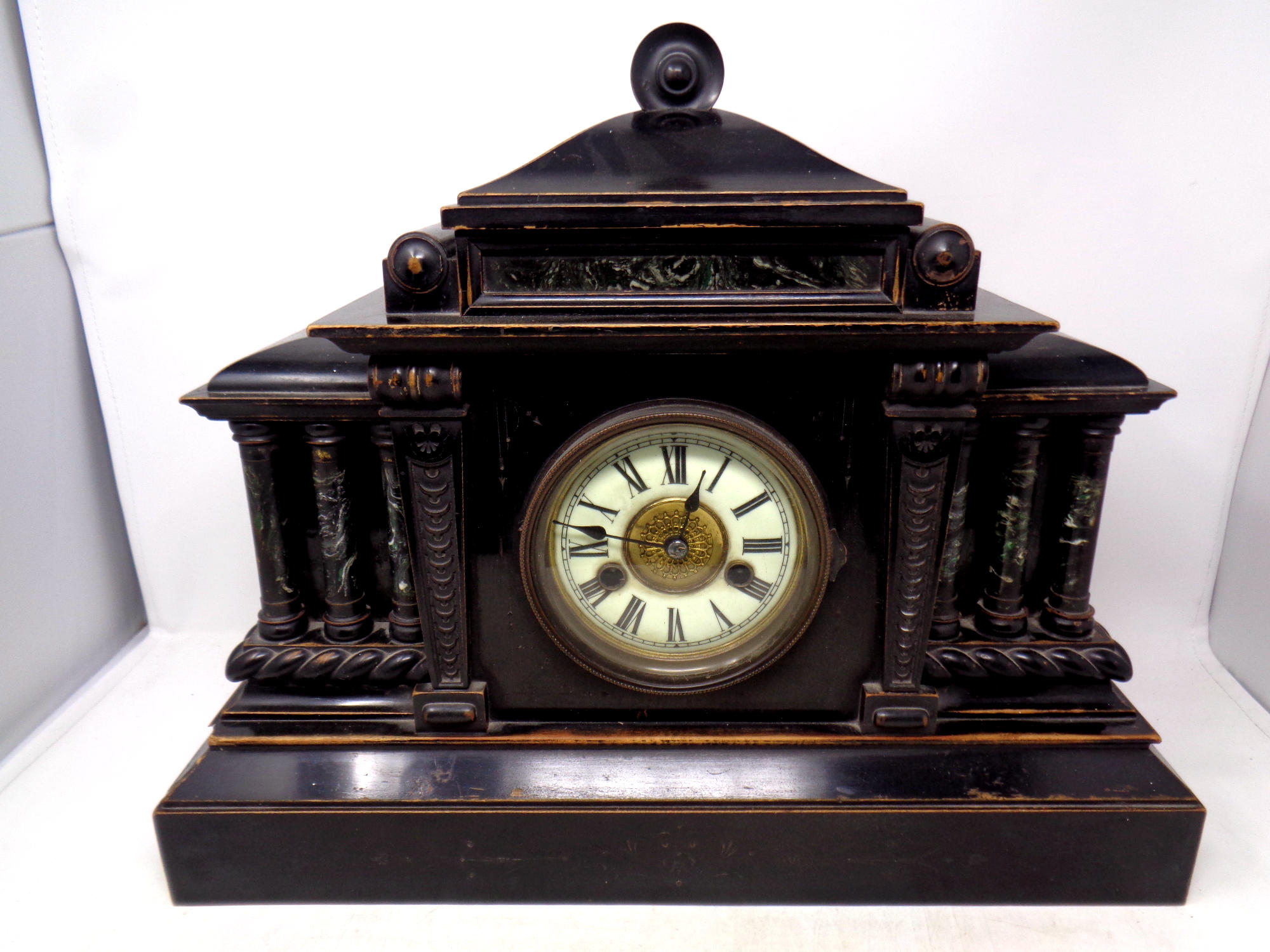 A 19th century ebonised wooden mantel clock with brass and enamel dial