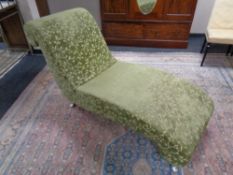 A contemporary chaise longue upholstered in a green fabric