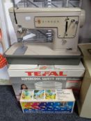 A cased Singer electric sewing machine together with a Ronco portable sewing machine, boxed,