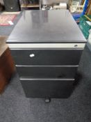 A metal three drawer under desk chest