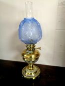 A Victorian brass oil lamp with glass shade and blue frosted glass shade