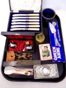 A tray containing cased silver plated butter knives, vintage spirit level, brass bell,