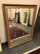 A large gilt framed bevelled overmantel mirror