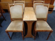 A mid 20th century teak G Plan drop leaf table together with a set of four chairs