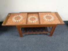 A mid 20th century teak extending tile topped coffee table