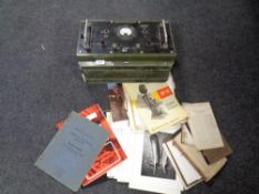 A vintage battery charger together with a box containing books and magazines relating to projectors