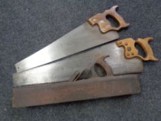 A vintage block plane together with two hand saws