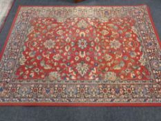 A machine made Persian design carpet on red ground,