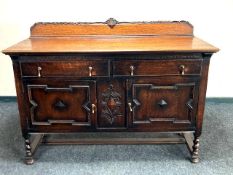 An Edwardian oak sideboard, fitted with two drawers above two cupboard doors, width 152 cm.