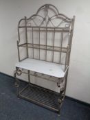 A wrought metal and wood four tier shelving unit