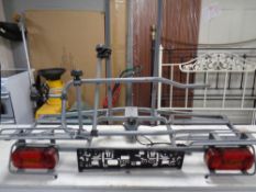 A vehicle mounted bike rack with number plate holder and lights