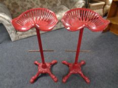 A pair of cast iron tractor seat breakfast bar stools