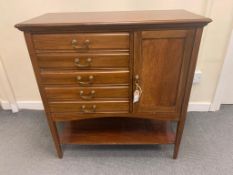 An Edwardian mahogany music cabinet, fitted with five drawers and a cupboard, with brass handles,