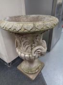 A concrete garden classical urn bearing ram's heads,