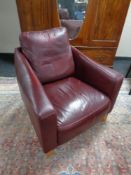 A contemporary armchair upholstered in Burgundy leather