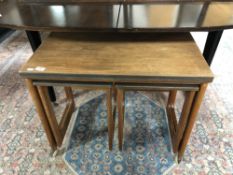 A nest of three mid 20th century teak turnover top tables