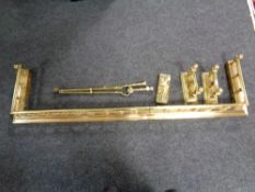 A Victorian brass fire curb together with fire dogs and companion set