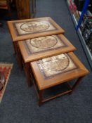 A nest of three mid 20th century Danish teak tile topped tables