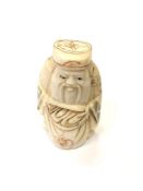 A Japanese carved bone netsuke - Village elder with a sack at his feet.