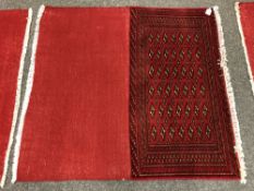 An eastern fringed cushion cover on red ground,