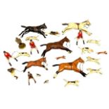 A carved wooden set of hunting figures including horses, hounds, foxes and riders.