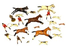 A carved wooden set of hunting figures including horses, hounds, foxes and riders.