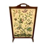 An early twentieth century oak folding table, with embroidered floral top with glass covering,