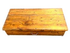 An early twentieth century pine storage box with hinged lid, width 124 cm, depth 61 cm,