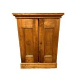 An early twentieth century pine double door cabinet, the panels marked 'H De Cabanas' , width 46 cm.