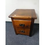 A stained pine two drawer bedside chest
