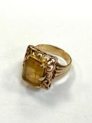 A yellow gold chunky dress ring set with a yellow stone, apparently unmarked,7.3g.