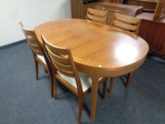 A 20th century teak oval extending dining table and four Nathan Teak dining chairs